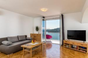 a living room with a couch and a tv and a table at Apartment Med in Dubrovnik