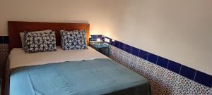 a bedroom with a bed with blue tile on the wall at Torre de la Campana in Cartagena