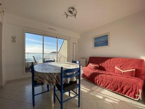 sala de estar con sofá rojo y mesa en 606 - Appartement à Erquy, à 700m de la plage et des commerces, en Erquy