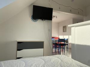1 dormitorio con 1 cama y TV de pantalla plana en la pared en 606 - Appartement à Erquy, à 700m de la plage et des commerces, en Erquy