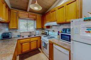 a kitchen with wooden cabinets and a white refrigerator at Awesome Views in Cambria