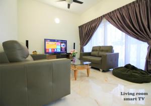 a living room with a couch and a tv at H2H - Bintang49 Vacation House in Ipoh