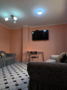 ein Wohnzimmer mit 2 Sofas und einem Flachbild-TV in der Unterkunft Hostal Venecia in Caral