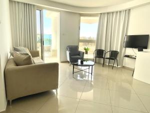 a living room with a couch and chairs and a table at Stylish 3BR Golf Residence Eilat in Eilat