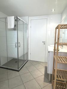 a shower with a glass door in a bathroom at Stylish 3BR Golf Residence Eilat in Eilat