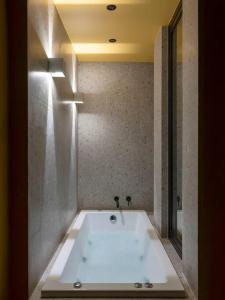 a white bath tub in a bathroom with a ceiling at Hoppersgr- Amazing apt in the heart of Athens - 6 in Athens