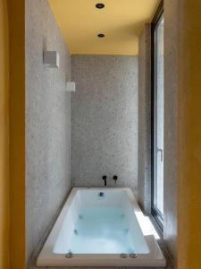 a large bath tub in a room with a window at Hoppersgr- Amazing apt in the heart of Athens - 6 in Athens
