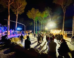 Une foule de gens se promenant autour d'un parc la nuit dans l'établissement Interpals Eco Resort, à Pals
