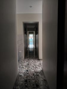 einen Korridor eines leeren Zimmers mit einem langen Flur in der Unterkunft Hostal Venecia in Caral