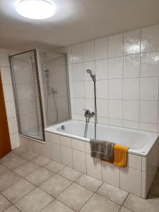 a white bathroom with a tub and a shower at Ferienwohnung Lux in Weißenburg in Bayern