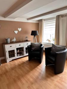 a living room with two chairs and a white cabinet at Ferienwohnung Lux in Weißenburg in Bayern