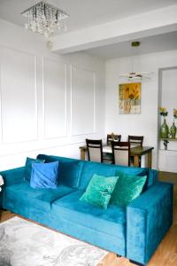 a blue couch in a living room with a table at Goldengreen Apartment in Kraków