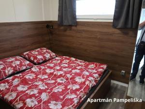 1 dormitorio con 1 cama con edredón rojo en Apartmány Štramberk, en Štramberk