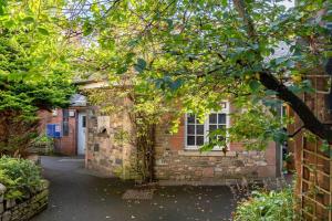 a brick house with a tree in front of it at Bijou apartment in the heart of Melrose in Melrose