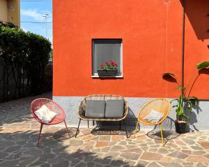 três cadeiras sentadas ao lado de um edifício com uma janela em La Perla em Monza