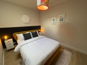 a bedroom with a large bed with white sheets at Bijou apartment in the heart of Melrose in Melrose