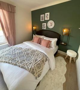 a bedroom with a large bed with pink pillows at Bijou apartment in the heart of Melrose in Melrose