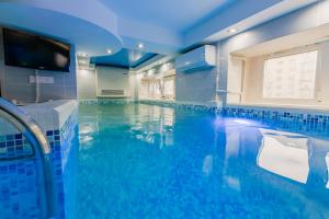 a large swimming pool with a tv in a room at Luxury Apartment with Pool and Hammam in Kyiv