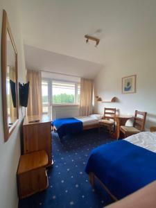 a hotel room with two beds and a desk at Ośrodek wypoczynkowy Kozioł in Kolno