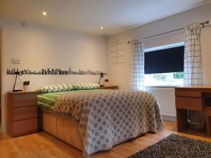 a bedroom with a bed and a desk and a window at Amazing flat in the middle of the golf course in Manchester