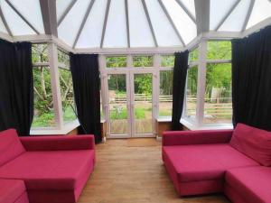 a living room with pink couches and windows at Amazing flat in the middle of the golf course in Manchester