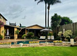 une maison avec une piscine dans une cour dans l'établissement Pin Oak Cottage, à Vryheid