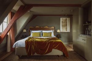 a bedroom with a large bed with yellow pillows at De Durgerdam, Amsterdam in Amsterdam