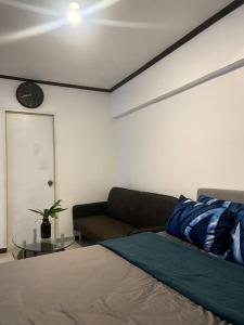 - une chambre avec un lit, un canapé et un réveil dans l'établissement The Bachelor's Suite at Mactan Airport, à Pusok