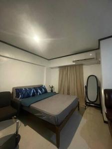 a bedroom with a large bed and a mirror at The Bachelor's Suite at Mactan Airport in Pusok