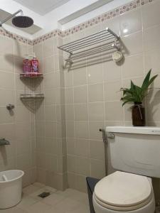 a bathroom with a toilet and a plant in it at The Bachelor's Suite at Mactan Airport in Pusok