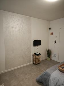 ベルガモにあるcasa Miriamのベッドルーム1室(壁にテレビとベッド1台付)