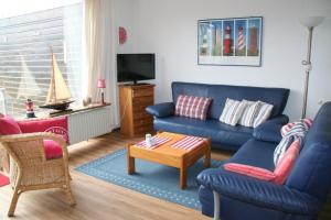 a living room with a blue couch and a table at Heggerank 66* in Nieuwvliet