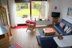 a living room with a blue couch and a table at Heggerank 66* in Nieuwvliet
