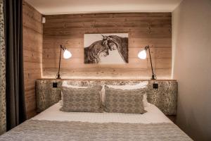 a bedroom with a bed with two lights above it at Au Coeur du Village in La Clusaz