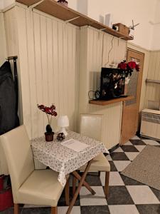uma mesa e cadeiras num quarto com piso de xadrez em Dunaparti Tímár Villa em Vác