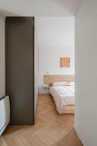 a bedroom with a bed in a white room at Corte Trastevere Verde, Business&Holiday, 4 ospiti in Rome