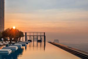 a pool of water with the sun setting in the background at One&Only One Za'abeel in Dubai