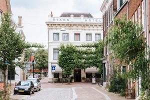 a white building with a sign on it on a street at Stadshotel Steegoversloot in Dordrecht