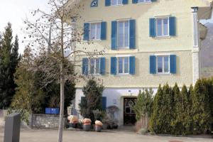 AlpnachにあるGerlis - relaxte Ferien in typischem Dorfhausの青いシャッターが付いた大きな建物