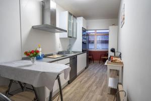 a kitchen with a table with a vase of flowers on it at Lembranzas in Padrón