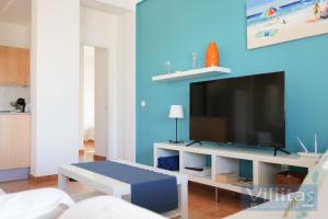 a living room with a tv on a blue wall at VILLA BERMEJA 20 by Villitas in Playa Blanca