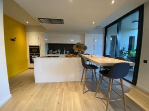 a kitchen with a table and chairs in a room at Maison d architecte Bruges/piscine chauffée/Tram D in Bruges