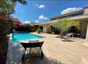a backyard with a swimming pool and a house at Maison d architecte Bruges/piscine chauffée/Tram D in Bruges