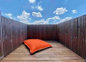 an orange pillow sitting on top of a wooden fence at Maison d architecte Bruges/piscine chauffée/Tram D in Bruges