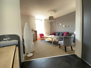 un soggiorno con un divano e un tavolo di 653 - Appartement à Erquy, à 100m de la plage et des commerces a Erquy