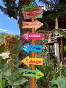 a street sign with many different signs on it at Hostería Arasari in Mindo