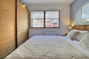 Un dormitorio con una cama grande y una ventana en Cocoon, Cozy & Chic, en Champéry