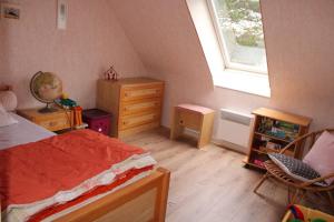 um quarto com uma cama, uma janela e uma cadeira em 655 - Appartement à Erquy, en centre bourg à 300m de la plage du centre em Erquy