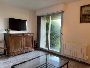 ein Wohnzimmer mit Flachbildfernseher und Fenster in der Unterkunft 656 - Charmant studio à Erquy, situé à environ 100m du centre 300m de la plage in Erquy