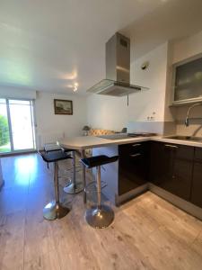 eine Küche mit einer Theke und Hockern darin in der Unterkunft 656 - Charmant studio à Erquy, situé à environ 100m du centre 300m de la plage in Erquy